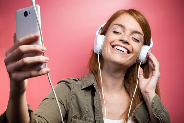 Снимок Красивой Улыбающейся Женщины Слушающей Музыку Наушниками Розовом Фоне — стоковое фото