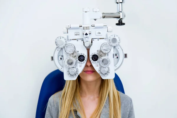 眼科で光 Phoropter と視力測定を行うかなり若い女性のショット — ストック写真
