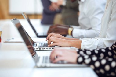 Genç iş adamları el üstünde onların laptop üzerinde coworking yer çalışma yakın çekim.