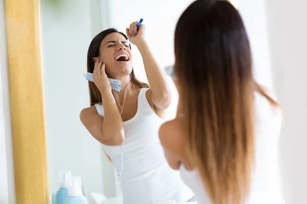 自宅の浴室で彼女の歯をブラッシングしながら時間を楽しむかなり若い女性のショット — ストック写真