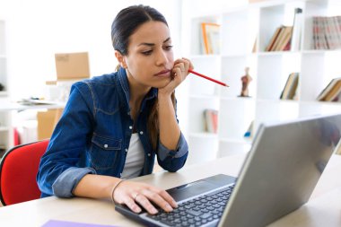 Oldukça genç işkadını laptopunu ofisteki çalımakta kadeh.