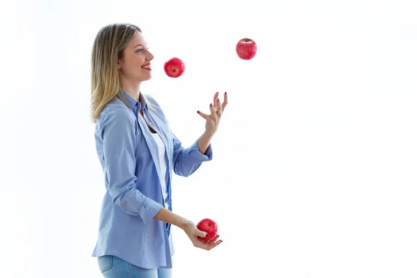 射击漂亮的年轻女子杂耍与红色苹果在白色背景 — 图库照片