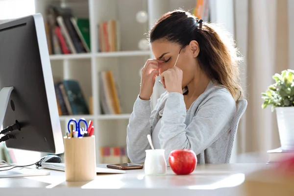 オフィス内のコンピューターでの作業中に頭痛を持つ疲れの若いビジネス女性のショット — ストック写真
