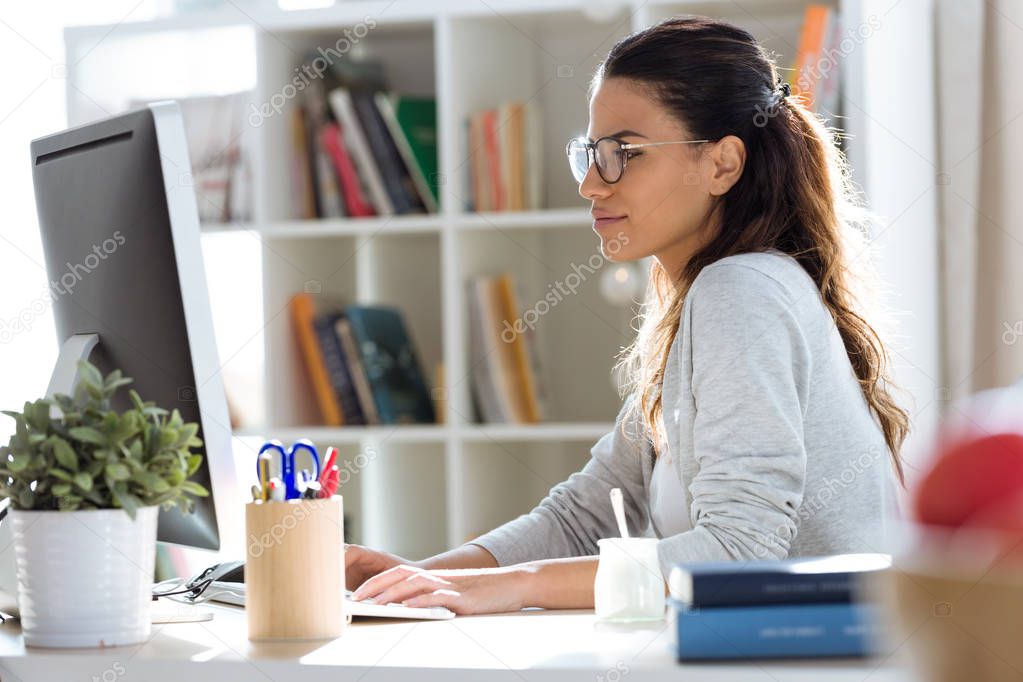 Shot of pretty young business woman working with her computer in the office.