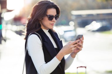 Sokakta duran cep telefonu kullanan genç ve güzel kadın görüntüsünü.