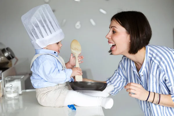 Foto Una Hermosa Madre Joven Mirando Bebé Con Sombrero Chef —  Fotos de Stock