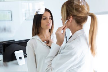 Kendine güvenen kadın ile stetoskop tıbbi danışma doktor tarafından muayene ediliyor kadeh.