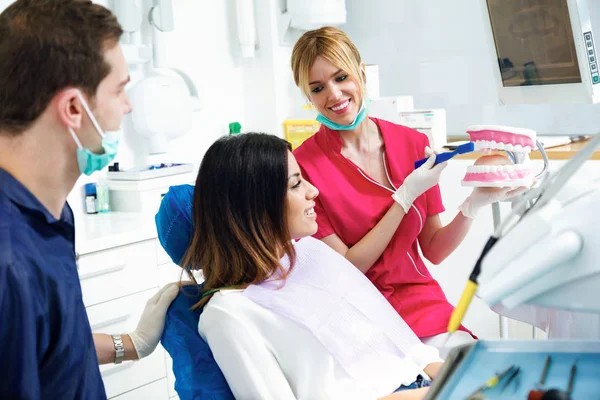 Foto Hermoso Dentista Explicando Cómo Cepillar Los Dientes Correctamente Paciente — Foto de Stock