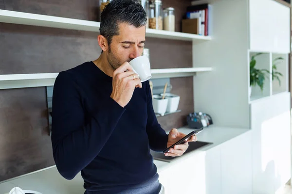 Tiro Jovem Bonito Usando Seu Telefone Celular Enquanto Bebe Café — Fotografia de Stock
