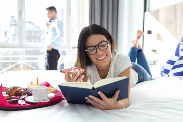 Bir Kitap Okuma Otel Odasında Yatakta Yatarken Kahvaltı Güzel Gülümseyen — Stok fotoğraf