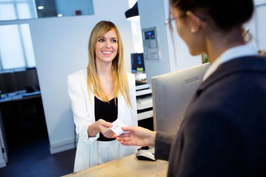 İstemci otelde oda anahtar kartı veren çekici kadın recepcionist kadeh.