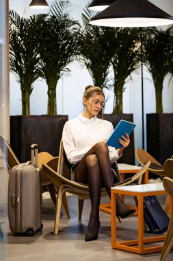 Otel lobisinde otururken ona dijital tablet ile çalışmaya konsantre genç iş kadını vurdu.