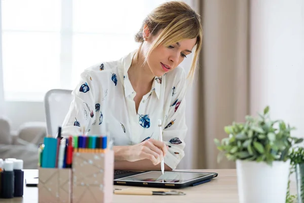 Professionale bella giovane designer donna disegno qualcosa sul suo tablet digitale in ufficio . — Foto Stock
