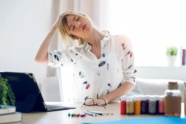 Mujer joven de negocios que estira el cuerpo para relajarse mientras trabaja con la tableta digital en la oficina . — Foto de Stock