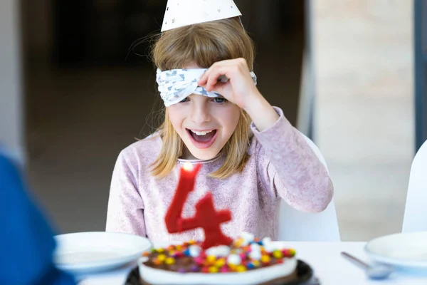 Engraçado menina surpresa e se divertindo com bolo de aniversário na cozinha em casa . — Fotografia de Stock