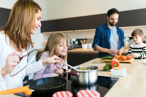 Симпатичная семья веселится, готовя вместе на кухне дома . — стоковое фото