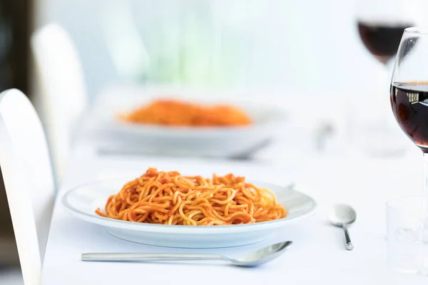 Вкусные спагетти с томатным соусом подаются на белой тарелке на кухне дома . — стоковое фото