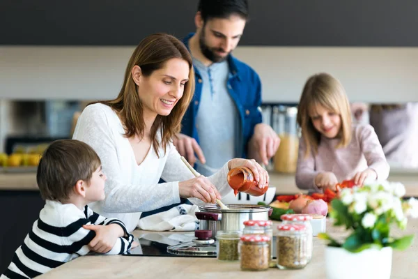 Hermosa linda familia divirtiéndose mientras cocinan juntos en la cocina en casa . — Foto de Stock