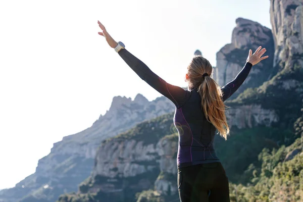 Trail Runner med öppna armar upp medan du njuter av naturen på bergstopp. — Stockfoto