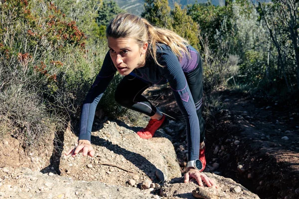 Sportig ung kvinna vandrare klättring brant stenig terräng på berget. — Stockfoto
