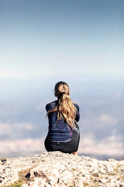 Trail Runner sitter och tar en paus medan du ser landskapet från Mountain Peak. — Stockfoto