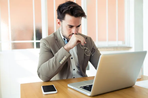 Snygg ung affärsman som arbetar med laptop på kontoret. — Stockfoto