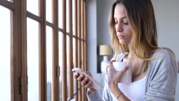 Evde Oturma Odasında Pencereye Yakın Kahve Içerken Onun Cep Telefonu — Stok video