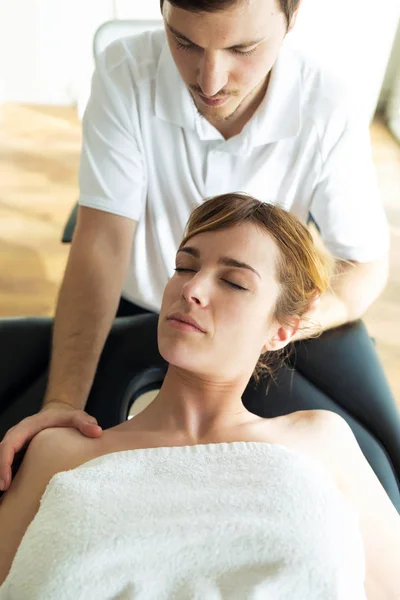 Mladý fyzioterapeut provádí léčbu krku pacientovi ve fyzioterapeutické místnosti. — Stock fotografie