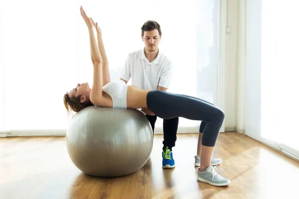 Fizyoterapist hasta fitness Ball Fizyo odasında egzersiz yapmak için yardım. — Stok fotoğraf
