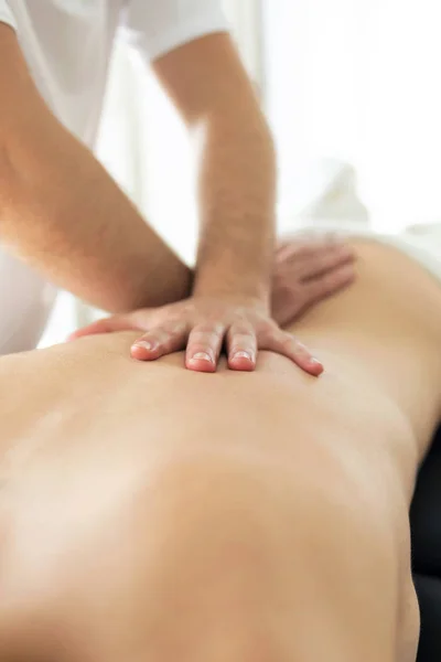 Young physiotherapist doing a back treatment to the patient in a physiotherapy room. — Stock Photo, Image