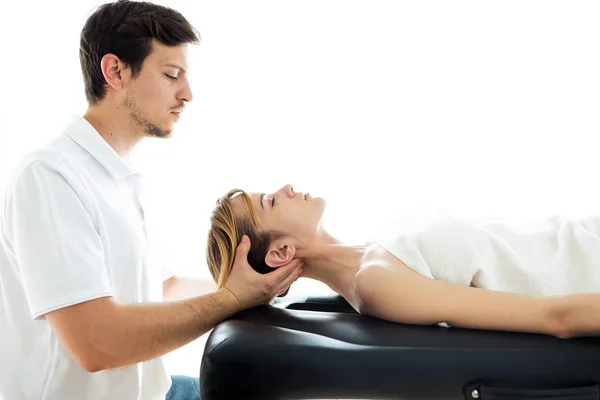 Mladý fyzioterapeut provádí léčbu krku pacientovi ve fyzioterapeutické místnosti. — Stock fotografie