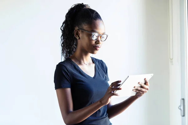 Mujer bastante joven usando su tableta digital en casa . — Foto de Stock