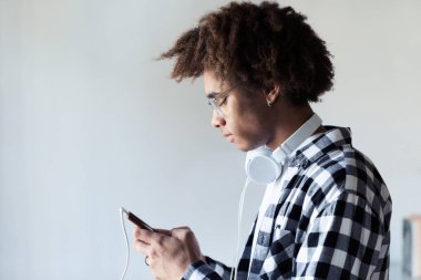 Yakışıklı genç afro-amerikan adam whit arka plan üzerinde cep telefonu kullanarak.