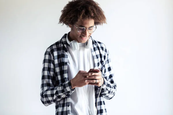 Bello giovane africano americano uomo utilizzando il suo cellulare su sfondo bianco . — Foto Stock