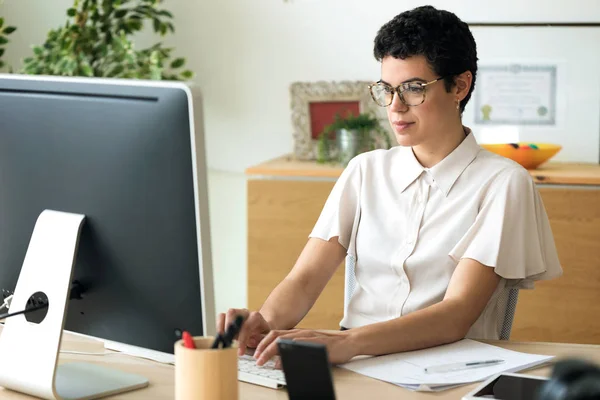 Jovem empresária concentrada trabalhando com seu laptop no escritório . — Fotografia de Stock