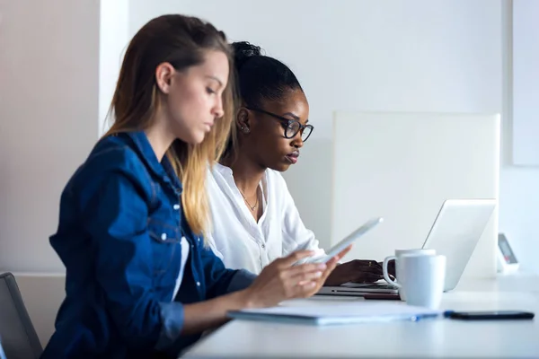 Két nagyon fiatal üzleti dolgozó nők digitális tabletta és laptop-ban az irodában. — Stock Fotó