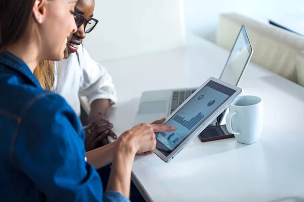 Twee mooie jonge zakelijke vrouwen werken samen met digitale tablet op kantoor. — Stockfoto