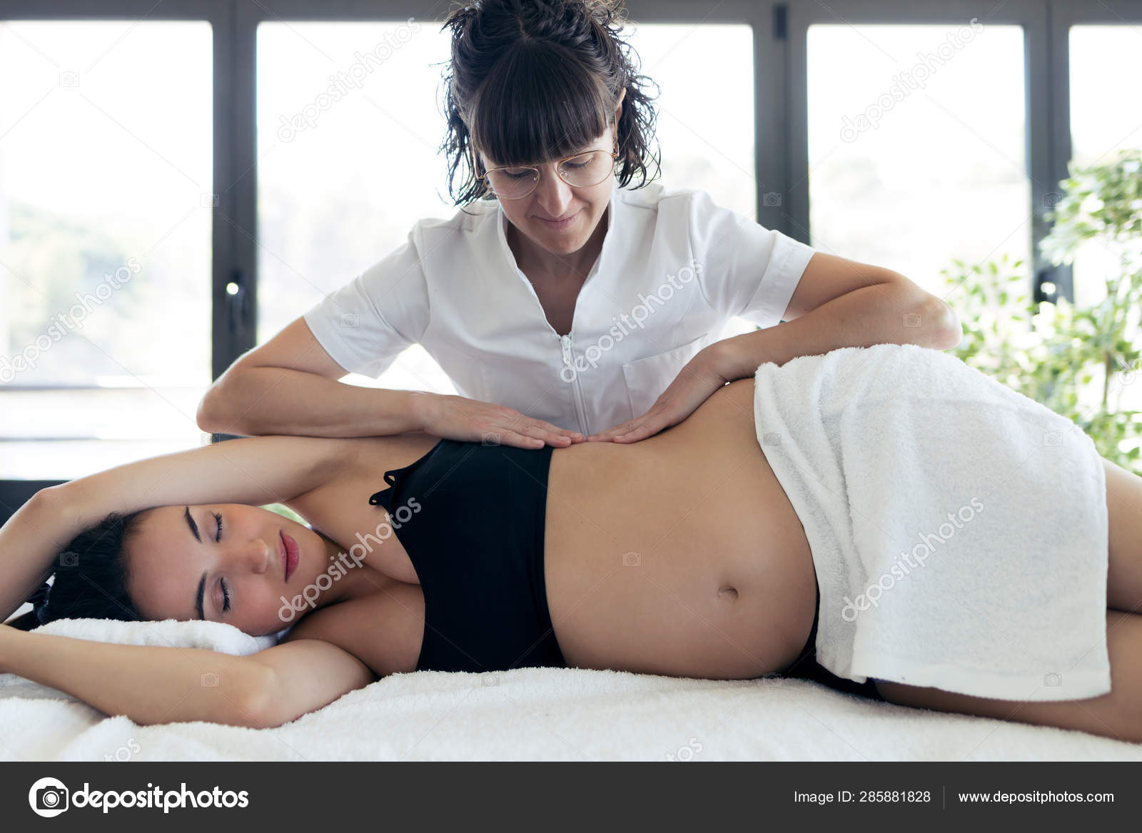 Fisioterapeuta haciendo masaje abdominal a hermosa mujer