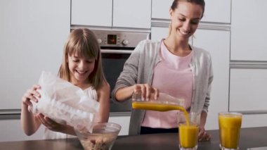 Video güzel genç anne ve kızı evde mutfakta kahvaltı hazırlanıyor.