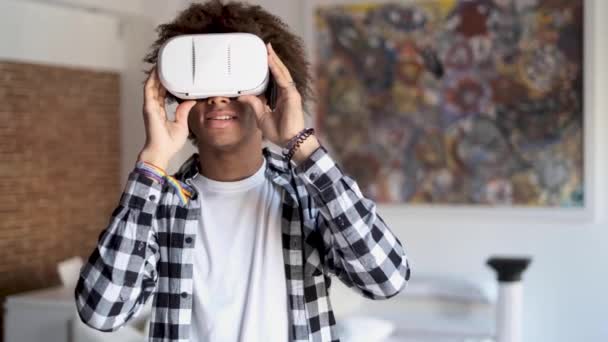 Šťastný Afroameričan mladý muž, který používá své virtuální reality brýle, když stojí doma. — Stock video