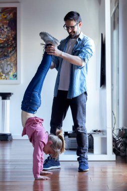 Güzel kızı evde çember yapmak için yardımcı yakışıklı genç baba