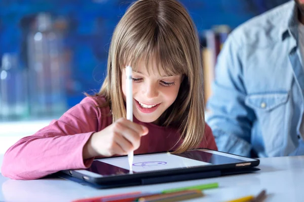 Muito feliz menina desenho com tablet digital em casa . — Fotografia de Stock