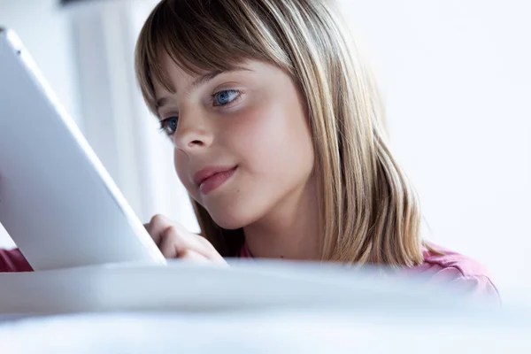 Vrij geconcentreerd klein meisje met behulp van haar digitale Tablet thuis — Stockfoto