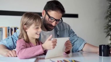 Evde dijital tablet kullanarak kızı ile yakışıklı genç baba.
