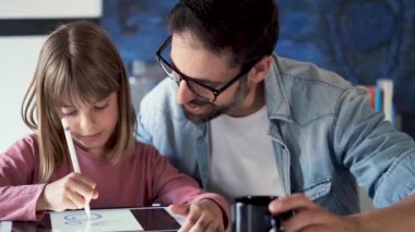 Evde dijital tablet ile kız çizim ile yakışıklı genç baba.