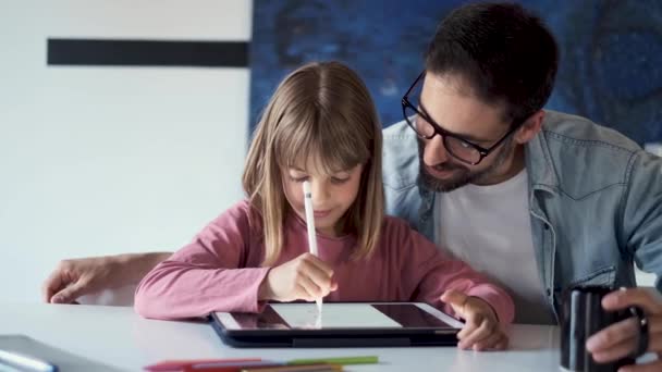 Guapo joven padre con su hija dibujo con tableta digital en casa . — Vídeo de stock