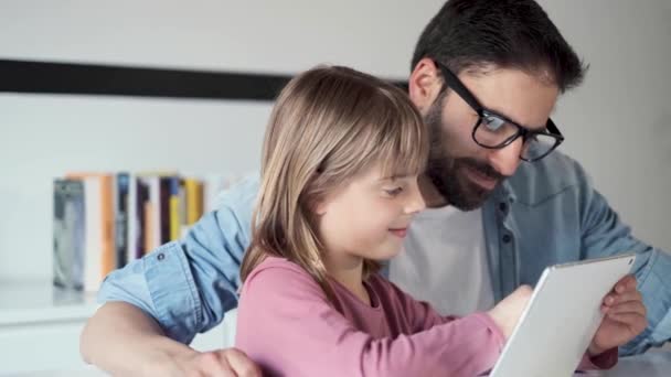 Bello giovane padre con sua figlia che usa il tablet digitale a casa . — Video Stock