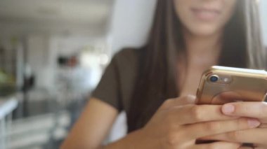 Ofiste cep telefonu ile mesaj gönderen gülümseyen genç iş kadını Video.