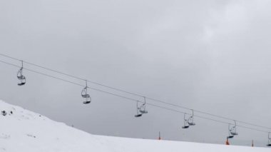 Telesiyejler bulutlu bir günde bir kayak merkezinde karlı dağa inerler.