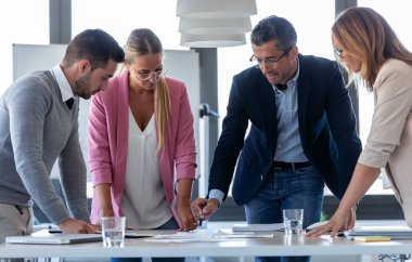 Yakışıklı işadamı ortak çalışma alanı toplantısında meslektaşları ile konuşuyor.